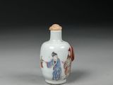 a white and red glass snuff bottle with a woman holding a fan