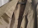 the jacket is hanging on a hanger next to a white curtain