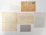 several old letters and envelopes are displayed on a white surface