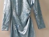 une robe bleue suspendue à un cintre contre un mur