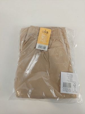 un pantalon kaki pour homme dans un sac en plastique posé sur une surface blanche
