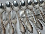 a lot of silver spoons and forks on the table
