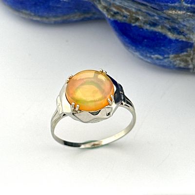 an image of a ring with an orange stone in the middle