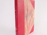 a red book with a red cover on a white surface