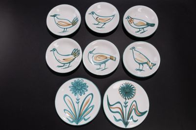 six assiettes ornées d'oiseaux, posées sur une table