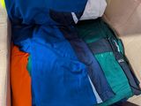 a cardboard box filled with many different colored shirts