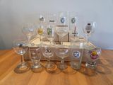 bottles and glasses on a wooden table with a box of wine glasses