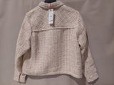 a close up of a sweater hanging on a hanger on a wall