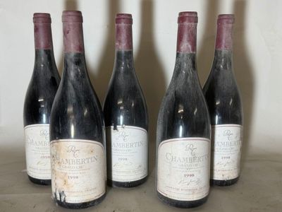 six bottles of red wine are lined up on a table