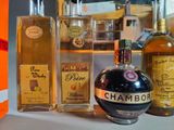 bottles of liquor are lined up on a counter in front of a shelf