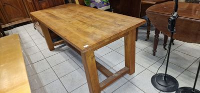 une table et des chaises en bois dans une pièce où se trouve un piano