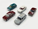 several toy cars are lined up in a row on a white surface