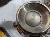 a silver cup sitting on top of a table next to a wallet