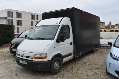 un camion blanc garé sur un parking à côté d'une voiture bleue