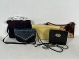 three purses and a handbag are sitting on a table