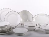 beaucoup d'assiettes et de bols blancs sur une table