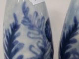 pair of blue and white vases sitting on top of a white table