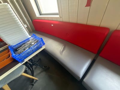 un banc rouge et blanc dans une pièce, près d'une fenêtre