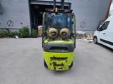 un chariot élévateur jaune garé devant un bâtiment