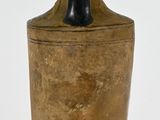 a black and gold vase sitting on a white surface
