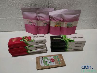 trois paquets de savon et un savon en pain posés sur une table