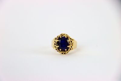 une bague en or avec une pierre bleue au centre
