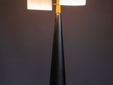 a black table lamp with a white shade on top of it