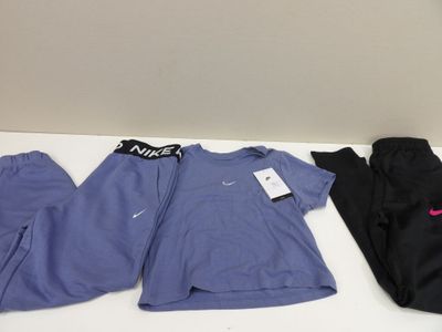 three pairs of nike scrubsuits and a t - shirt on a table