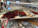 many rolls of fabric on a shelf in a room