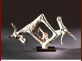 sculpture représentant un cheval et son cavalier, posée sur un socle en bois, sur fond gris