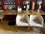 deux chaises placées devant une table sur laquelle sont posées des bouteilles de vin