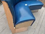 a blue leather chair with a wooden seat on the sidewalk