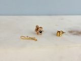 un gros plan sur une paire de boucles d'oreilles posées sur une surface en marbre