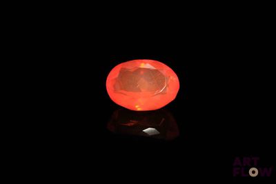 a close up of a red diamond on a black surface
