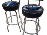 two black and chrome bar stools with a blue logo on the back