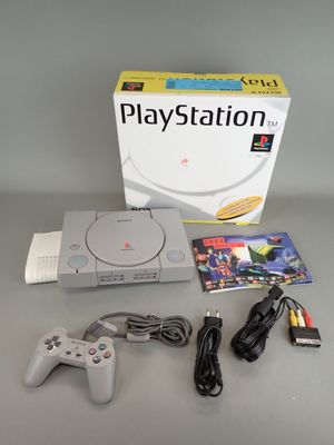 the game console is sitting on the table next to the box