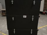 three black boxes stacked on top of each other in a warehouse