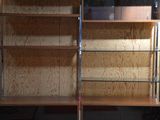 a wooden bookcase with glass shelves in a room