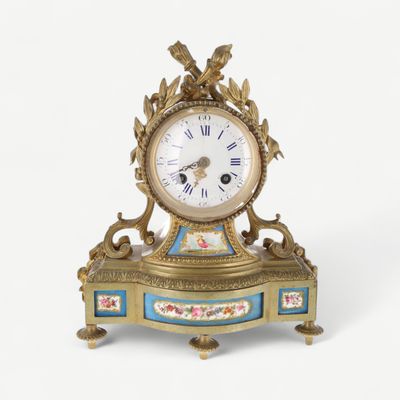 a clock that is sitting on a stand on a white surface