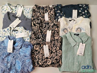 several shirts are lined up in a row on a shelf