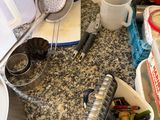 a picture of a cluttered kitchen counter with various items on it