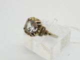 une bague sertie d'un diamant, posée sur une boîte transparente