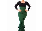 a woman in a green and black dress poses for a picture