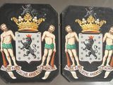 two plaques of men with crowns on them on the wall