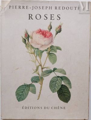 an old book with a rose on it sitting on a table