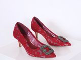 paire de chaussures rouges à talons hauts sur une surface blanche
