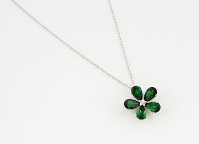 un gros plan d'un collier orné d'un trèfle à quatre feuilles