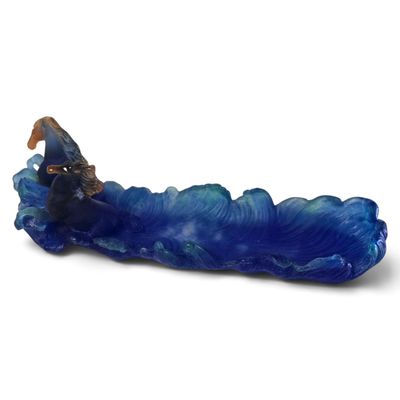 une figurine représentant un homme chevauchant une vague sur une planche de surf