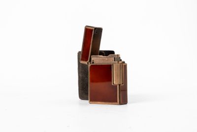 un briquet marron et noir posé sur une surface blanche