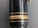 a close up of a pen with a gold band on it